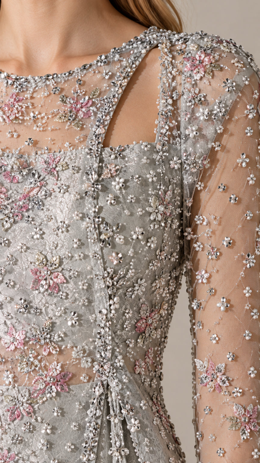 Close-up detail of intricate floral beadwork, sequins, and asymmetric cutout neckline on silver tunic