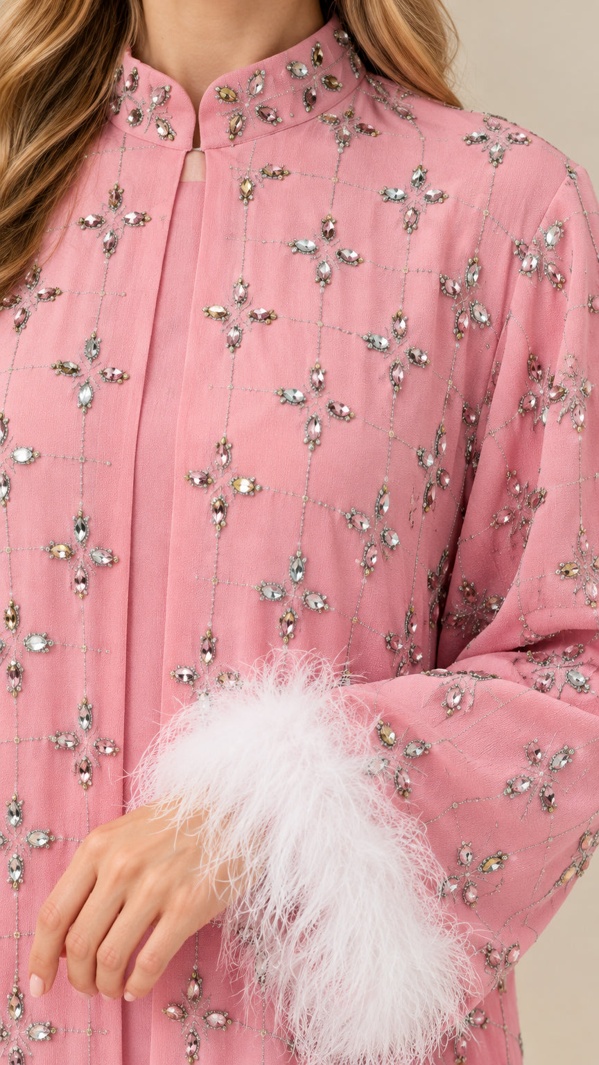 Close-up of sparkling rhinestone embellishments and plush feather cuff on dusty pink gown