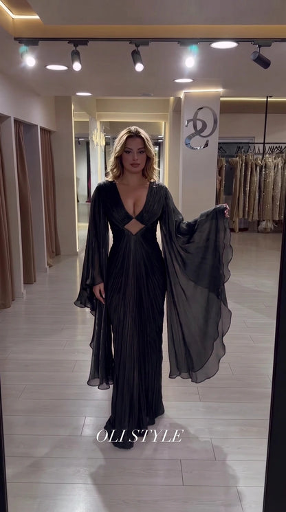 Black pleated evening gown with plunging neckline and dramatic cape flutter sleeves