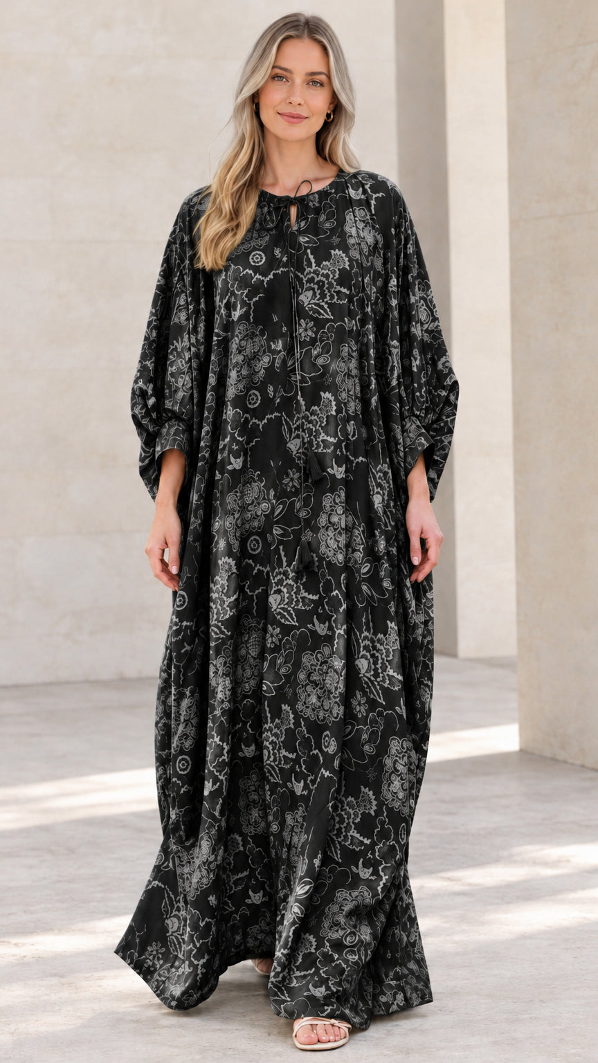 Front view of woman wearing black floral print caftan maxi dress