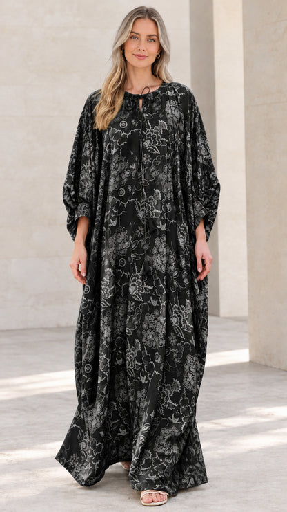 Front view of woman wearing black floral print caftan maxi dress