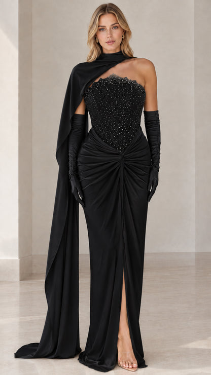 Full-length front view of black embellished corset evening gown with cape and gloves