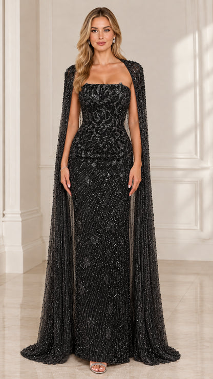 Front view of woman wearing black strapless beaded evening dress with cape overlay