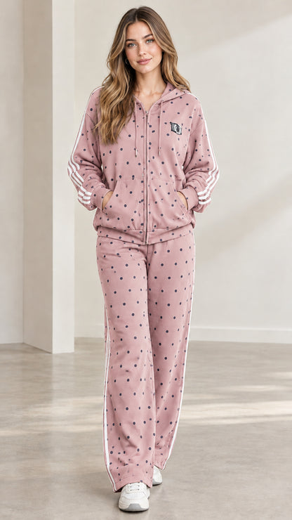 Model wearing dusty rose pink polka dot hooded tracksuit set with white side stripes