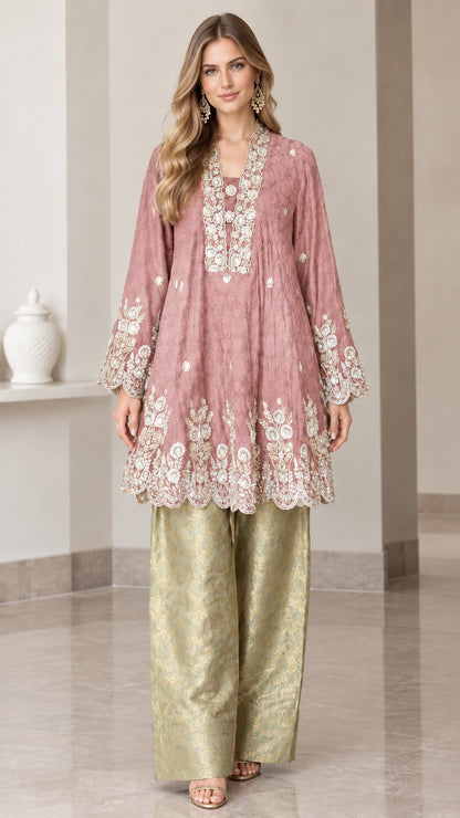 Model wearing dusty pink embroidered flared tunic top