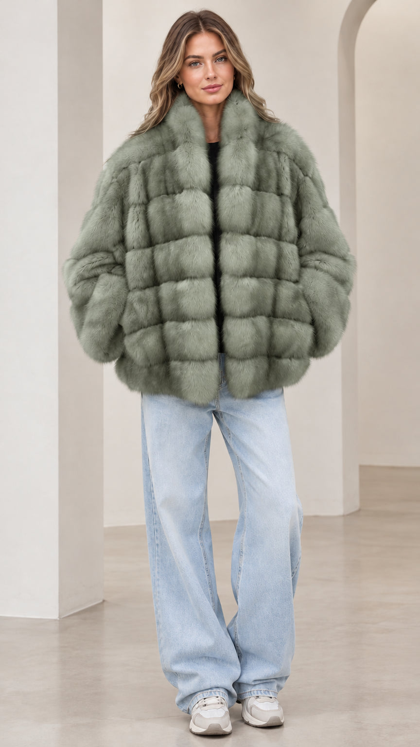Front view of model wearing the sage green paneled faux fur jacket