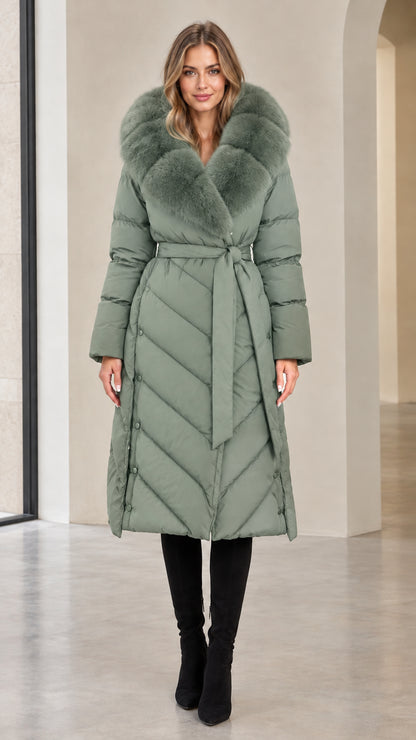 Full-length view of woman in sage green chevron quilted long puffer coat with fur hood