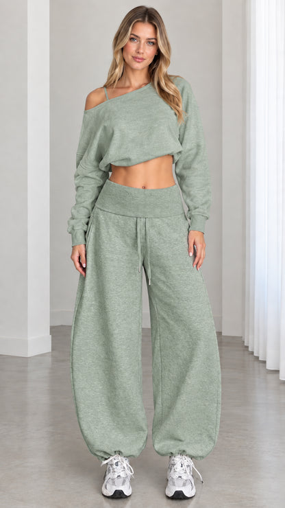 Model wearing sage green 2-piece off-shoulder crop top and matching balloon jogger sweatpants