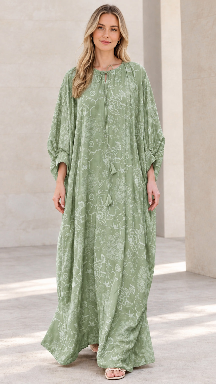 Front view of woman wearing sage green floral print caftan maxi dress