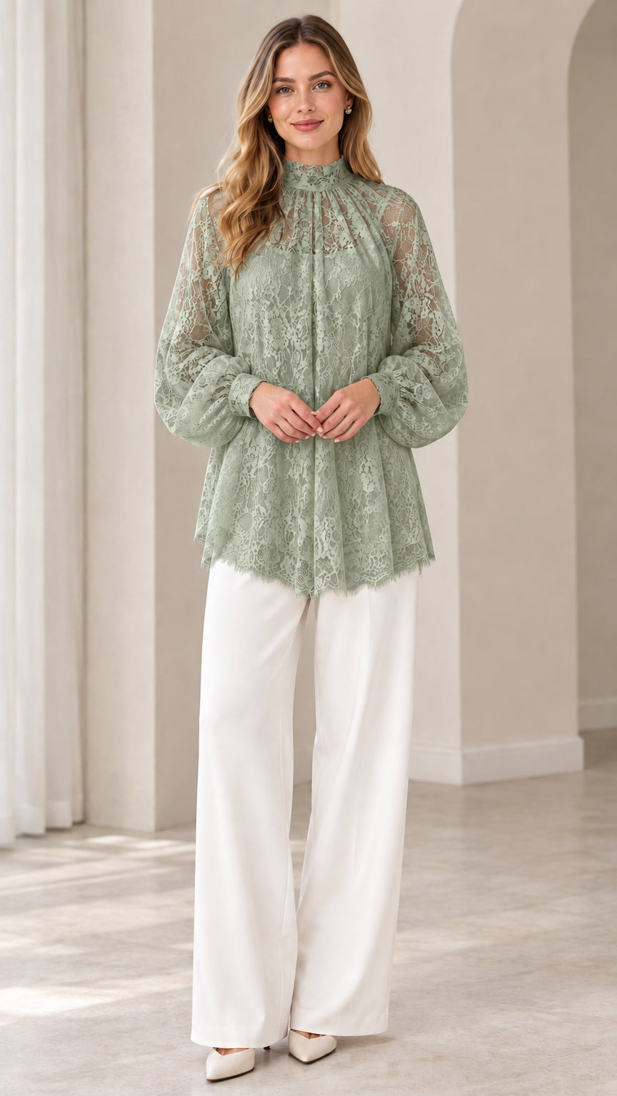 Full look of woman wearing sage green high neck floral lace blouse with white wide leg pants