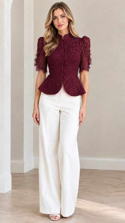 Model wearing burgundy floral lace peplum blouse with white trousers