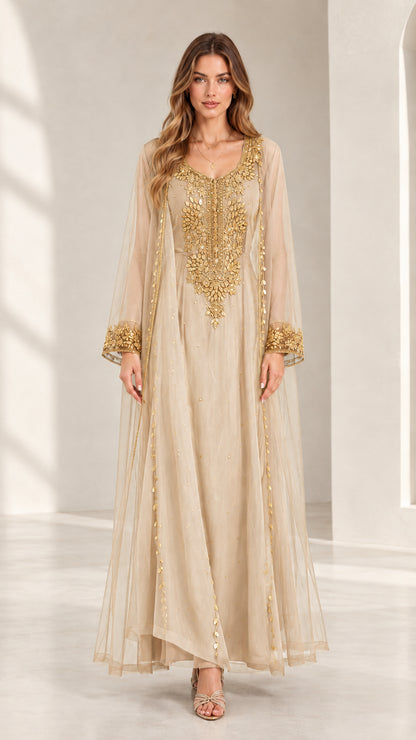 Front view of woman wearing champagne beige embroidered kaftan maxi dress with gold accents
