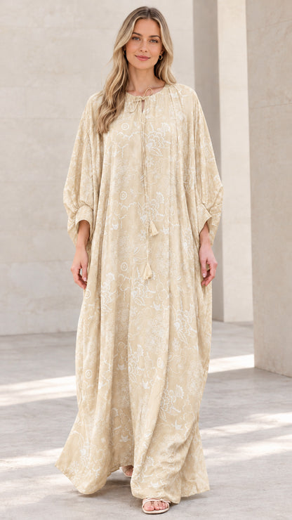 Front view of woman wearing beige floral print caftan maxi dress